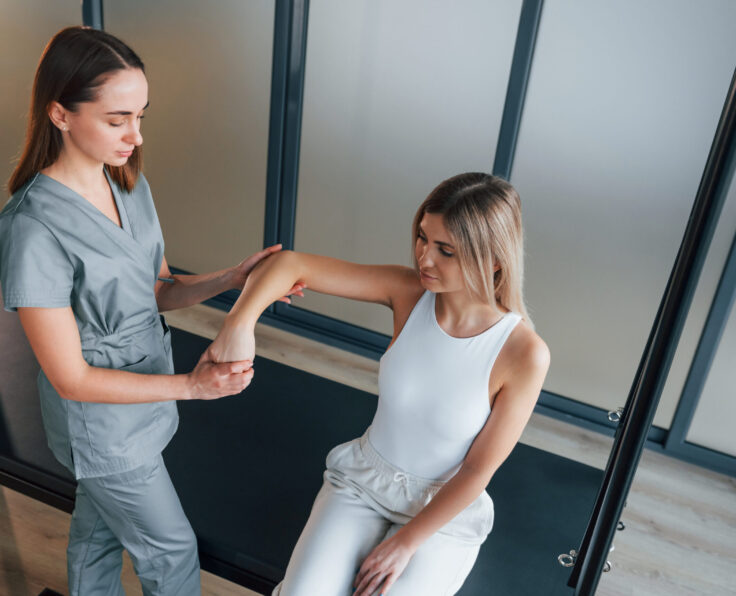 Moving the hand. Woman is in health center getting help by doctor.