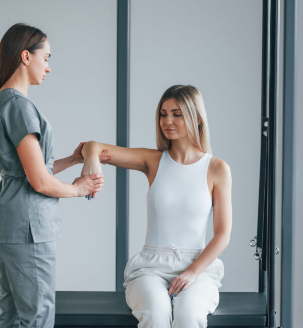 Moving the hand. Woman is in health center getting help by doctor.